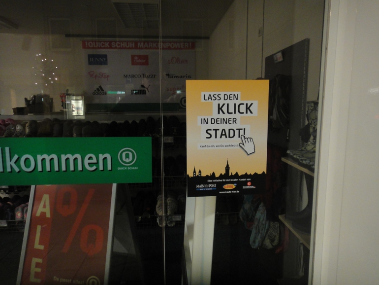 Banner der Kampagne "Lass den Klick in deiner Stadt" im Schaufenster von Quickschuh.