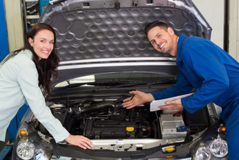 Mechanic smiling at the camera with customer