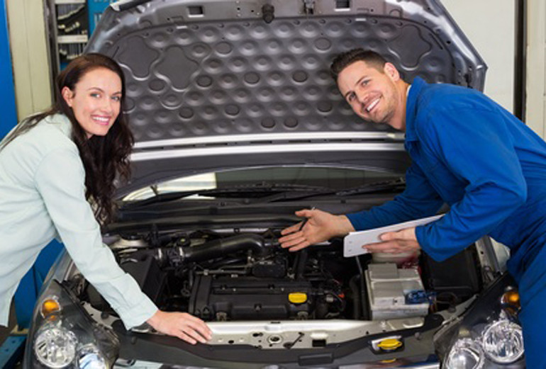 Mechanic smiling at the camera with customer